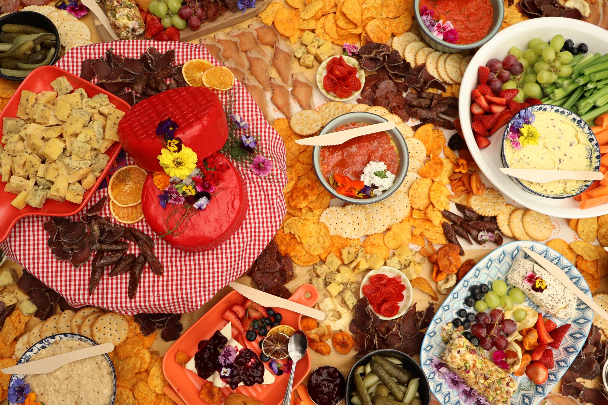 Overhead view of a Crafted Dairy grazing table with cheeses, dips, biltong and crackers